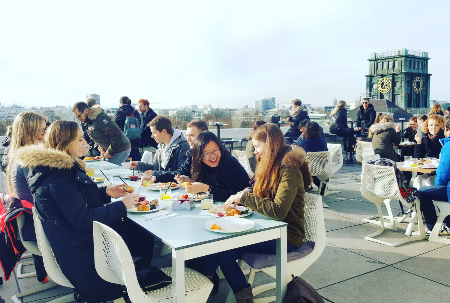 Students at a rooftop brunch with view of TUM main building